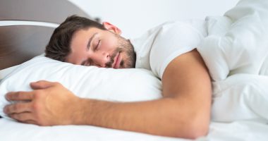 śpiący mężczyzna w białej pościeli