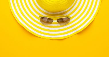 materac na lato, kapelusz i okulary na żółtym tle