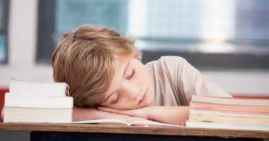 dziecko śpiące na biurku, czy szkoła i praca powinny zaczynać się po 10 rano